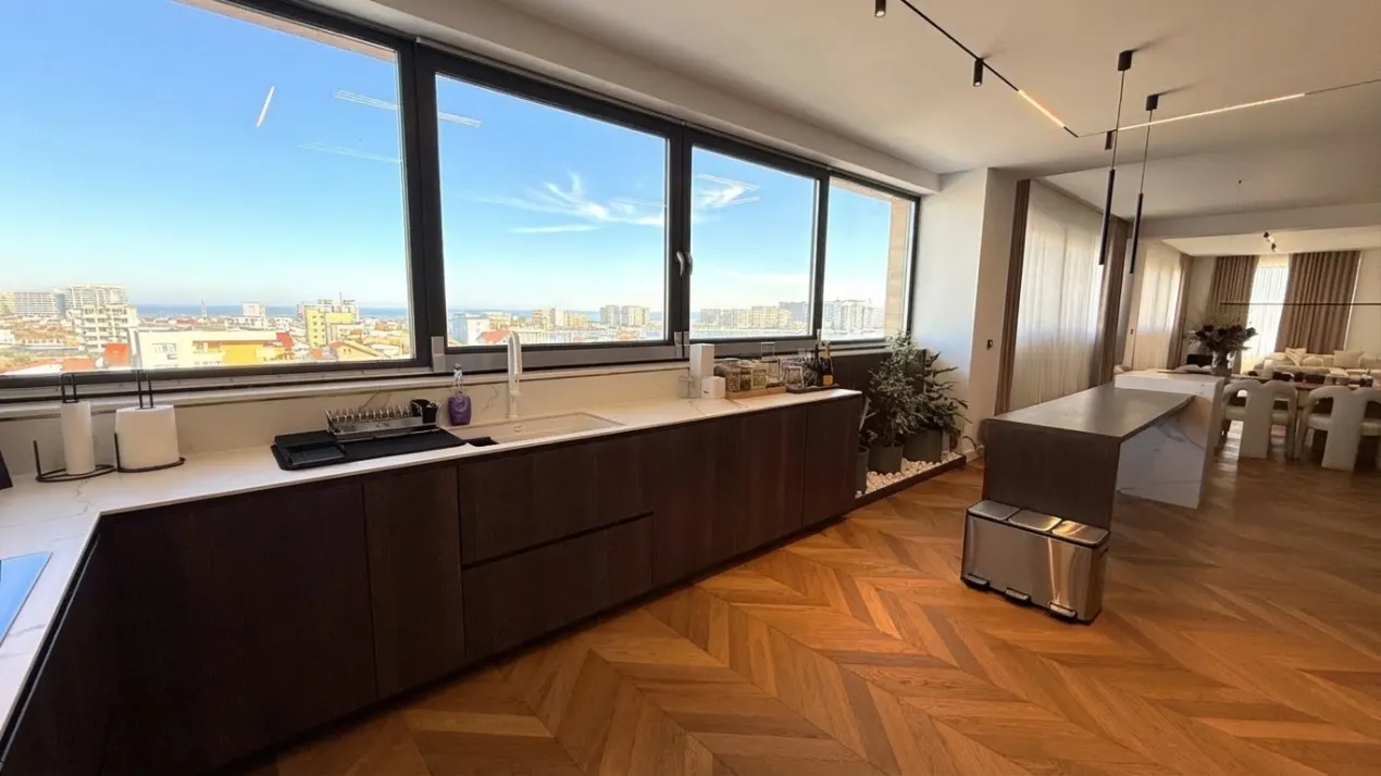 Zona de zi cu bucătărie și vedere panoramică în penthouse-ul XENERO Residence